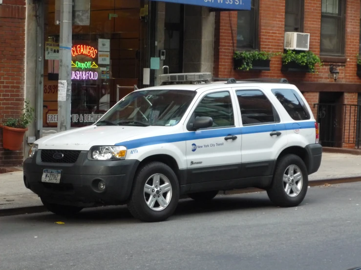 an suv parked outside a building with signs in the background