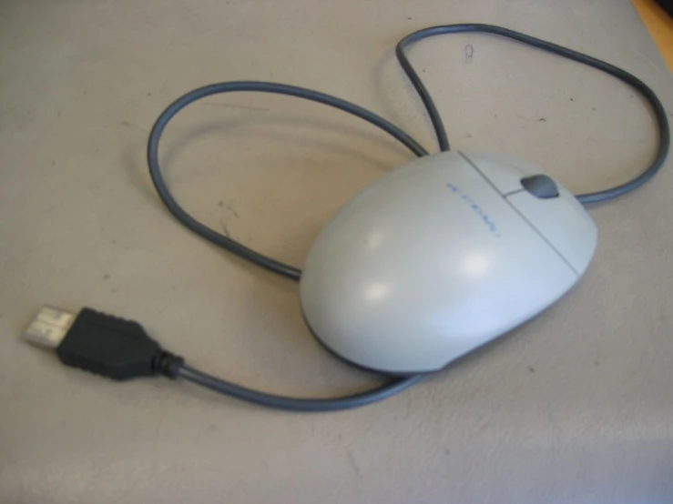 a white computer mouse is hooked up to a charger