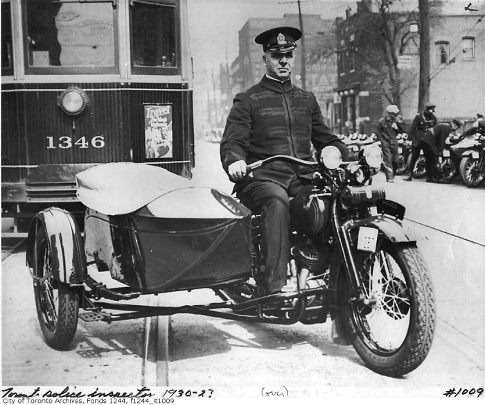 a man sits on an old motorcycle with a side car