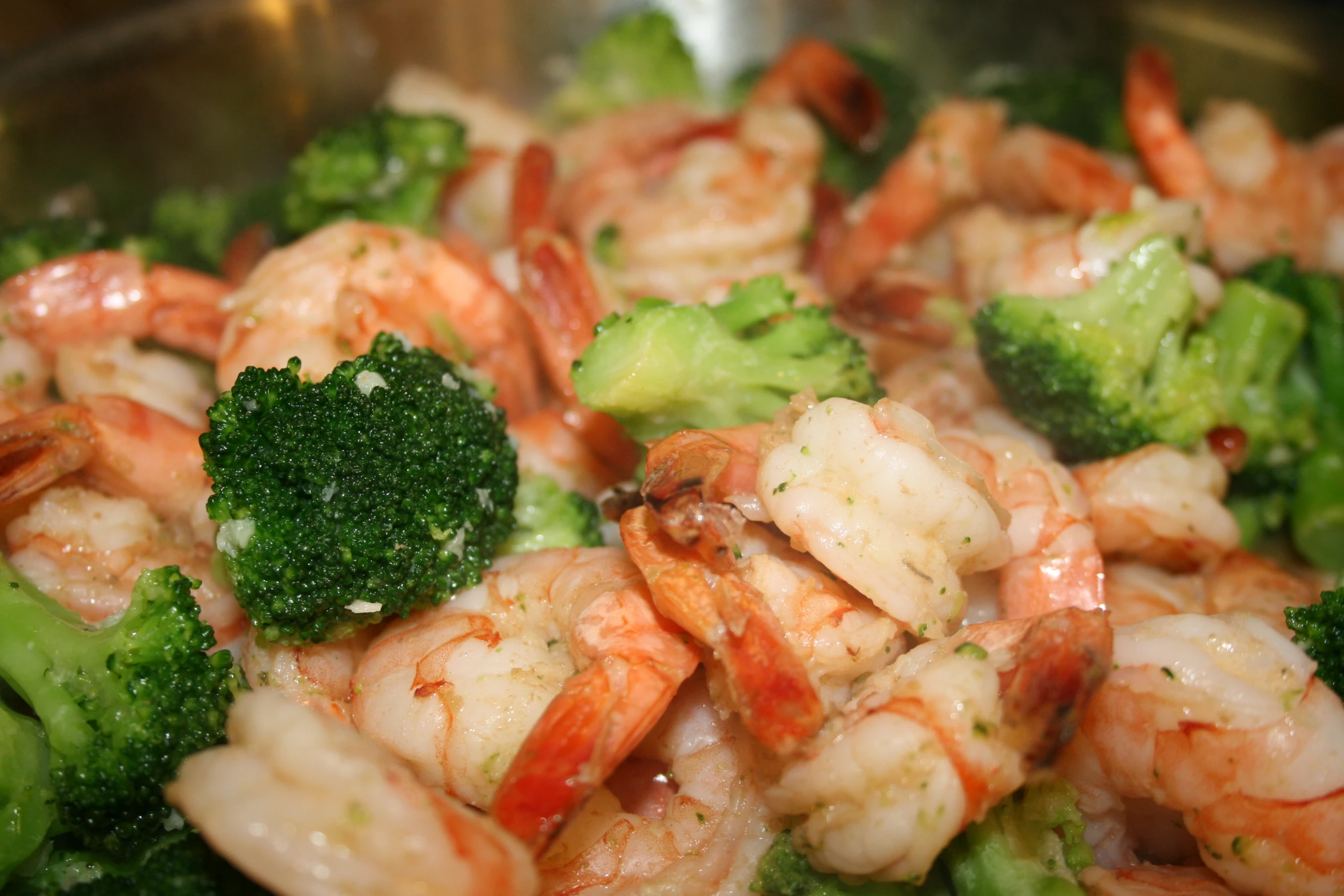 some shrimp and broccoli are fried together