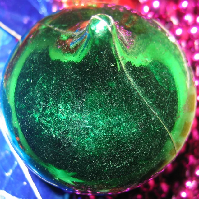 green glass ball on pink and purple sparkles