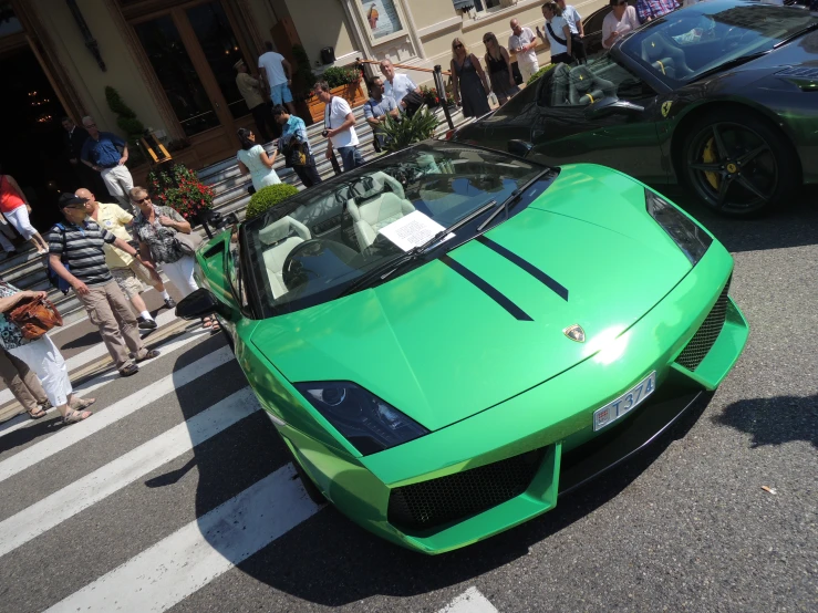 several cars on the street one is green and the other is black