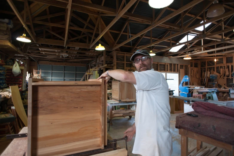 a man is standing over the top of a piece of furniture