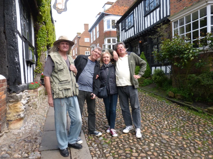 several people stand in front of houses while posing