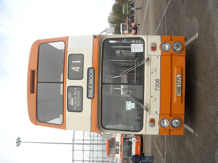 an orange and white truck parked in a parking lot