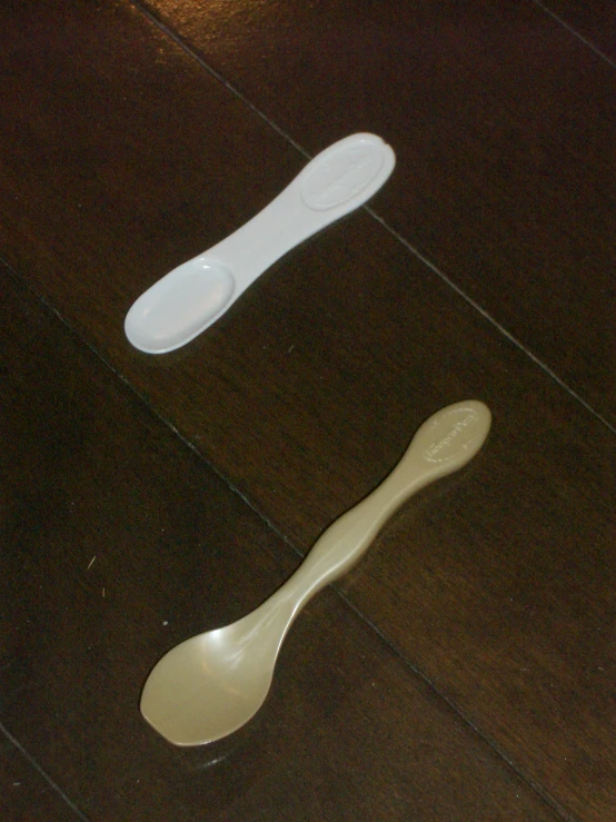 two white spoons one has a fork near it