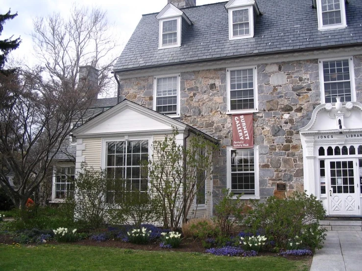 a large stone house has a clock on the front