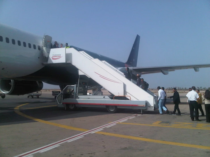 a large air plane with several people getting off