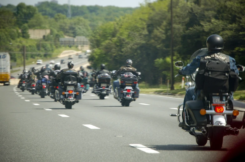a bunch of motorcycle riders driving down the road