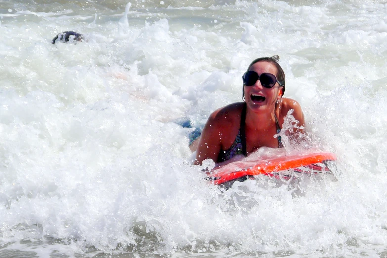 girl riding board in the water with a large splash