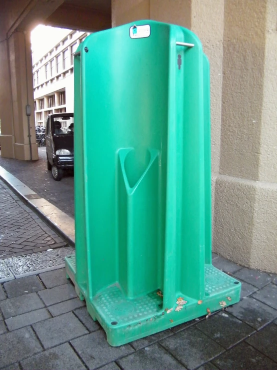 a public shower stall sitting on the sidewalk