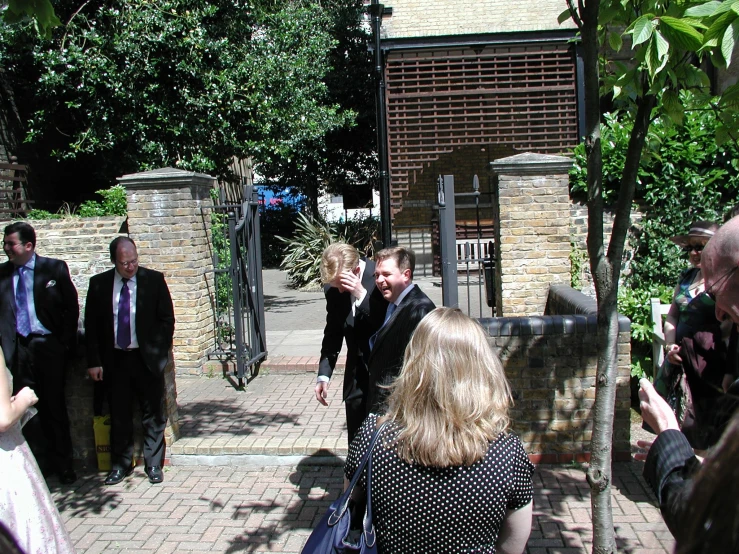 people stand outside of some buildings on their cell phones