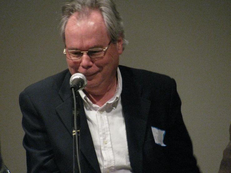 a man standing next to a microphone talking