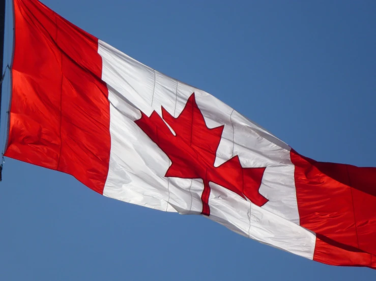 a canadian and canadian flag flying together in the air