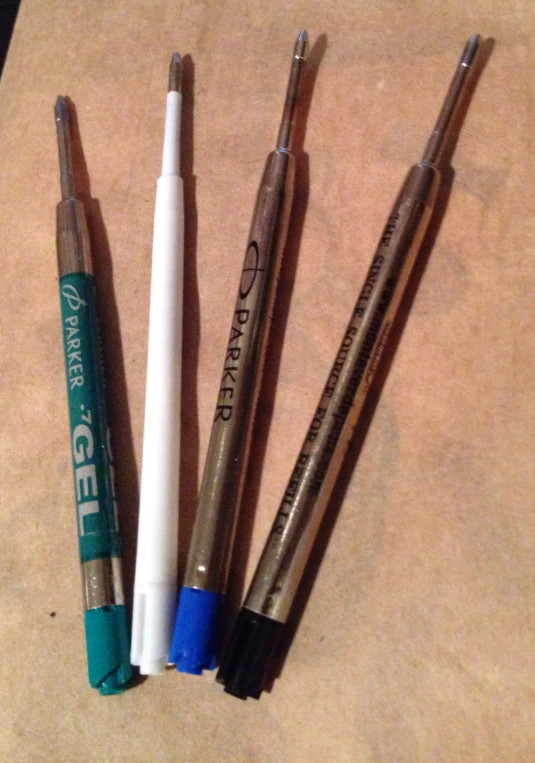 four pens sitting next to one another on a table