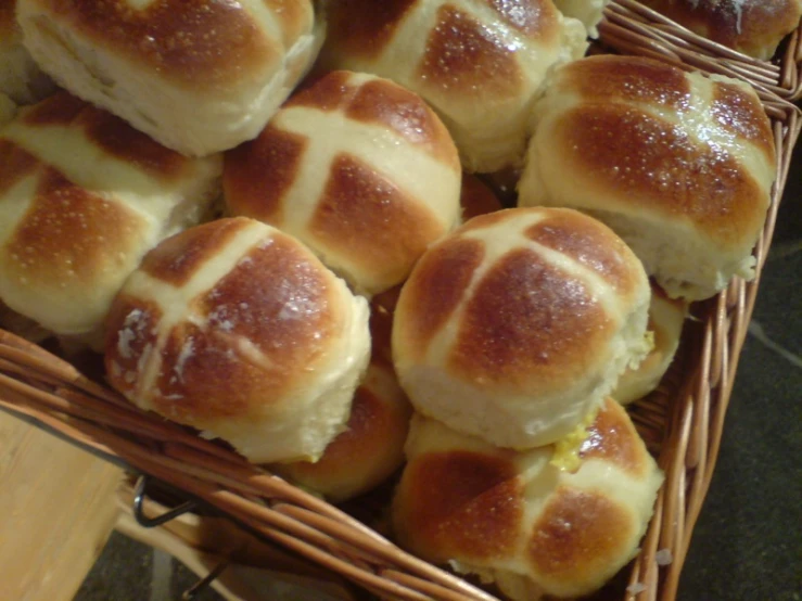 freshly made  cross buns displayed in basket
