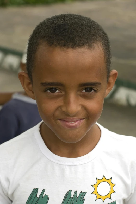 a boy wearing an african american shirt and smiling