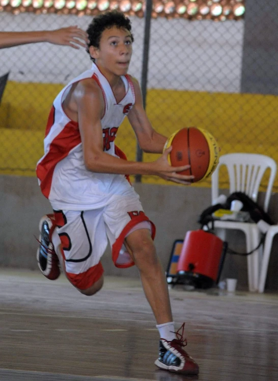 young men playing basketball on court in indoor arena