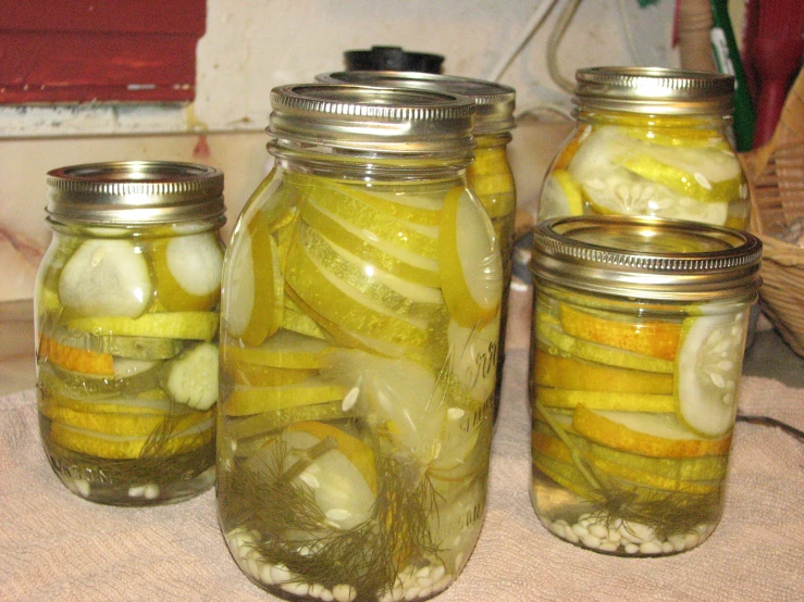 a jar filled with pickles sitting next to other jars