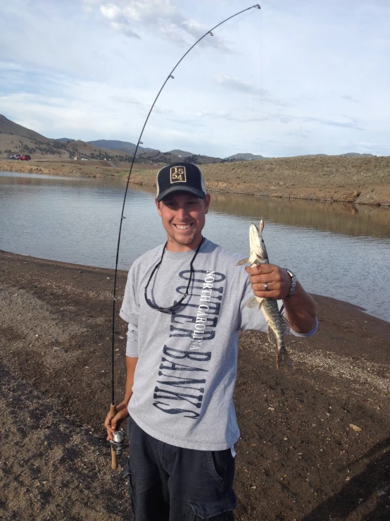 a man holding a fish on the water