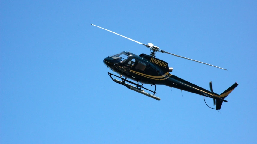 the helicopter is flying through the blue sky