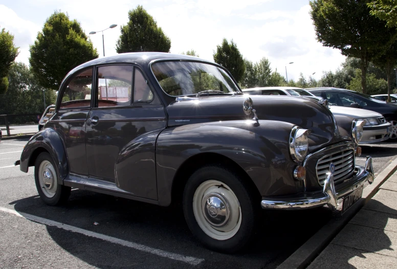an antique car is parked in a parking lot