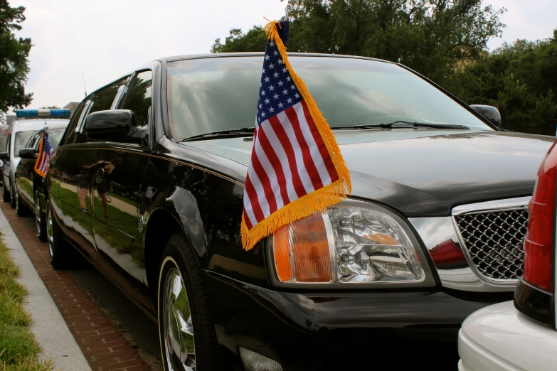 a flag sitting on the hood of a limousine