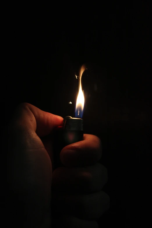 someone holding a lighter with a bright yellow flame