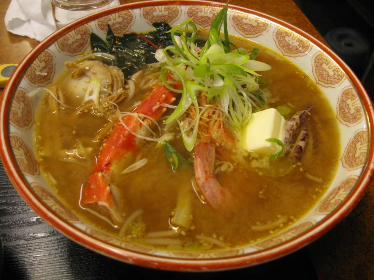 a bowl with a spoon, bread and soup on it