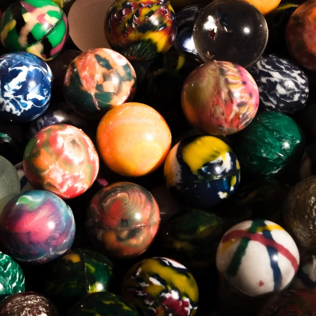 many colorful marbles on a black surface