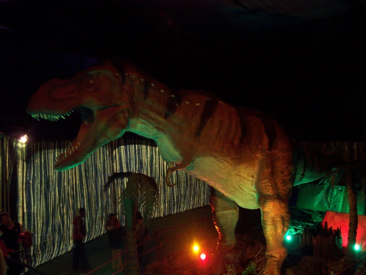 a fake dinosaur on display in front of people