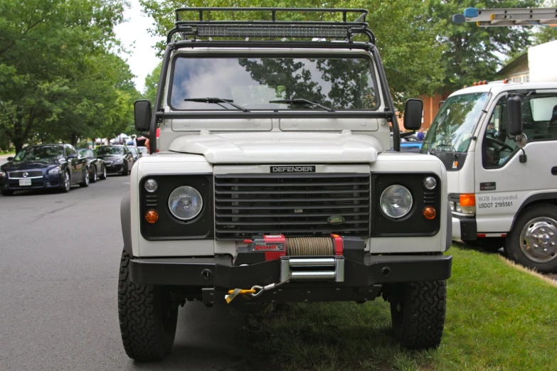 a white land rover is parked on the side of a road