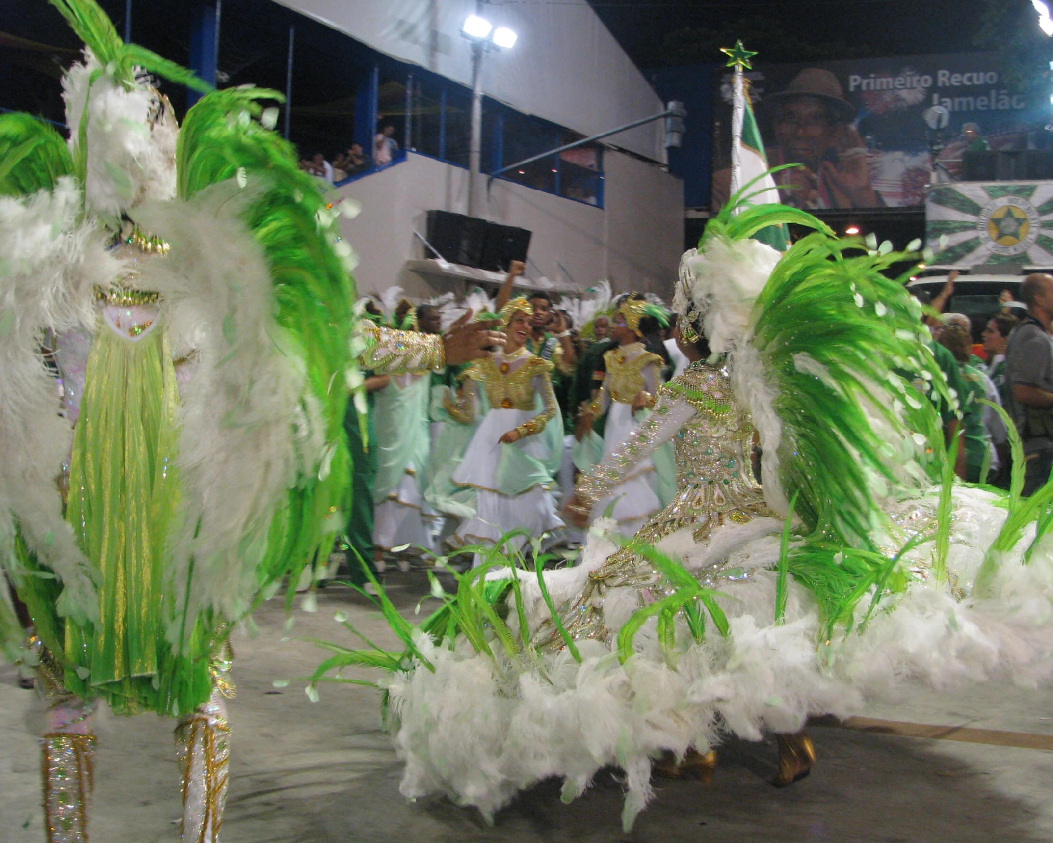 two elaborately decorated dancers on a street at night