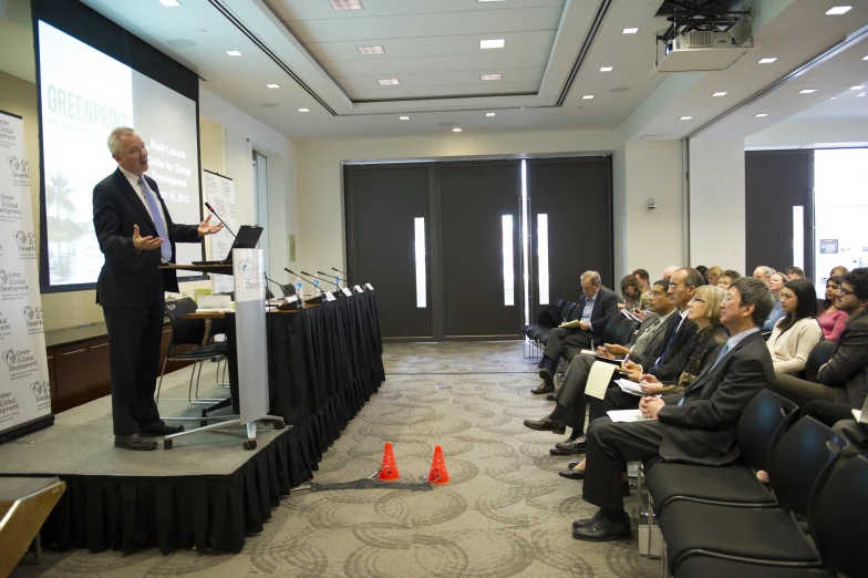 a man standing at a podium speaking into people