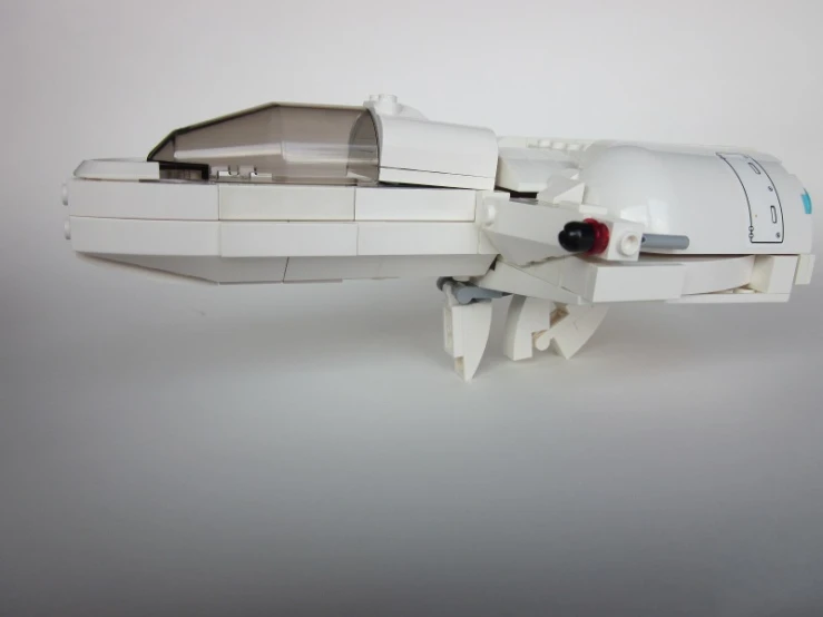 a white lego model of an insect with a large barrel on it's back end