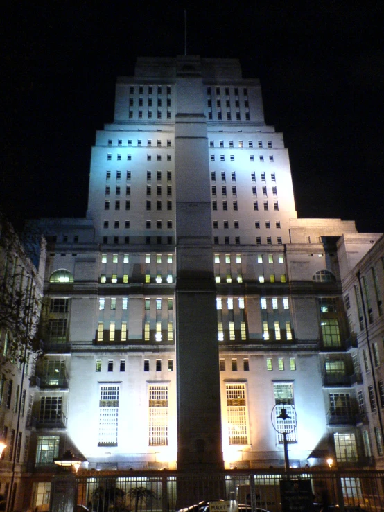 an apartment building at night, illuminated by street lights