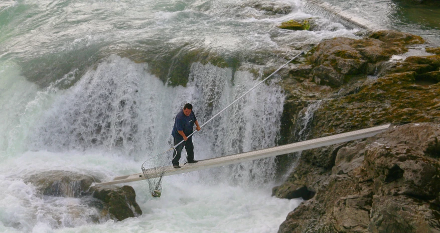 a man walking on a rope across a water fall
