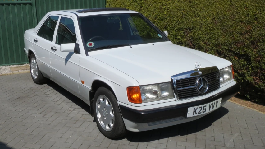 a white mercedes benz is parked on the street