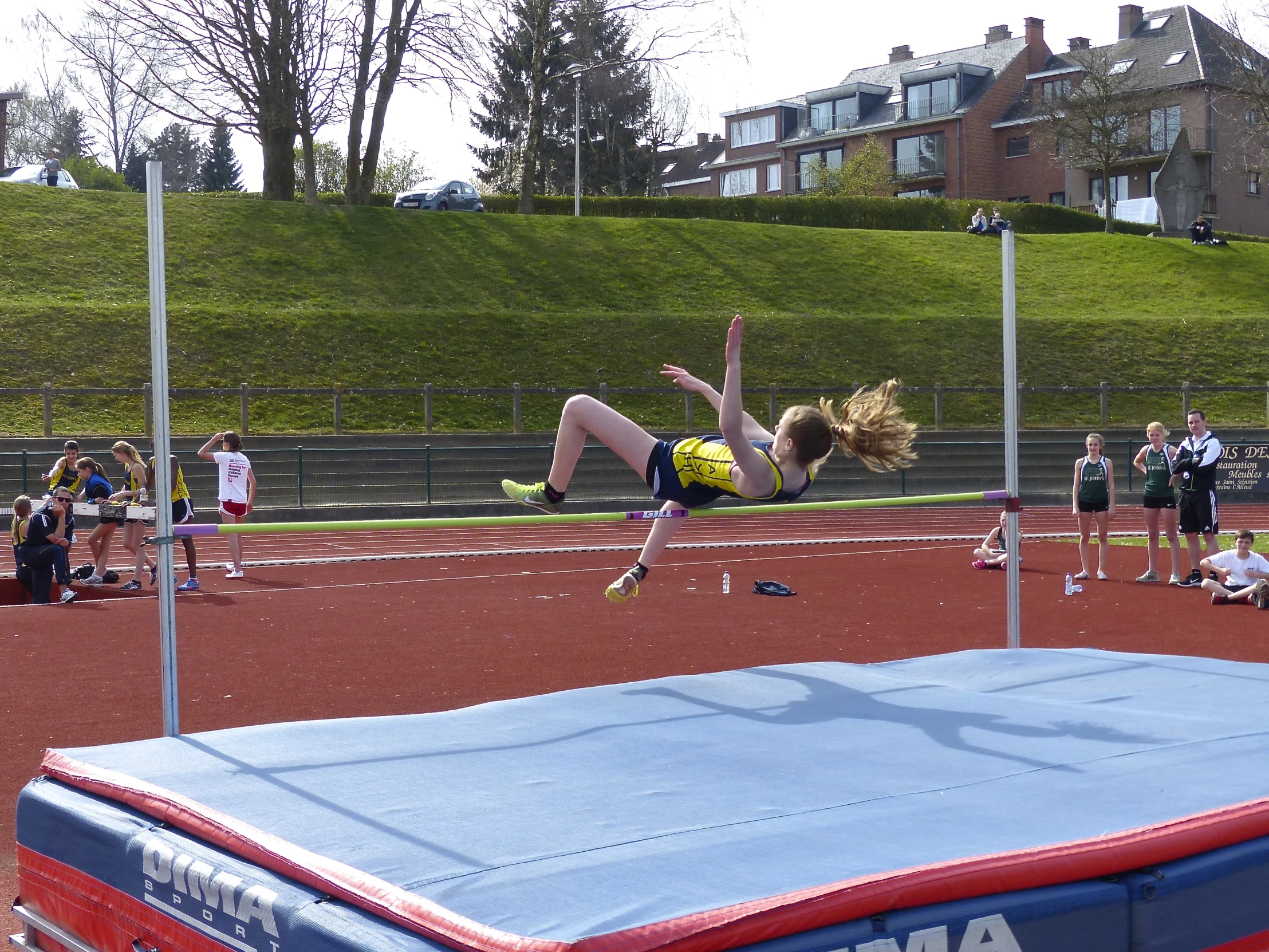 the female athlete is jumping over the bar