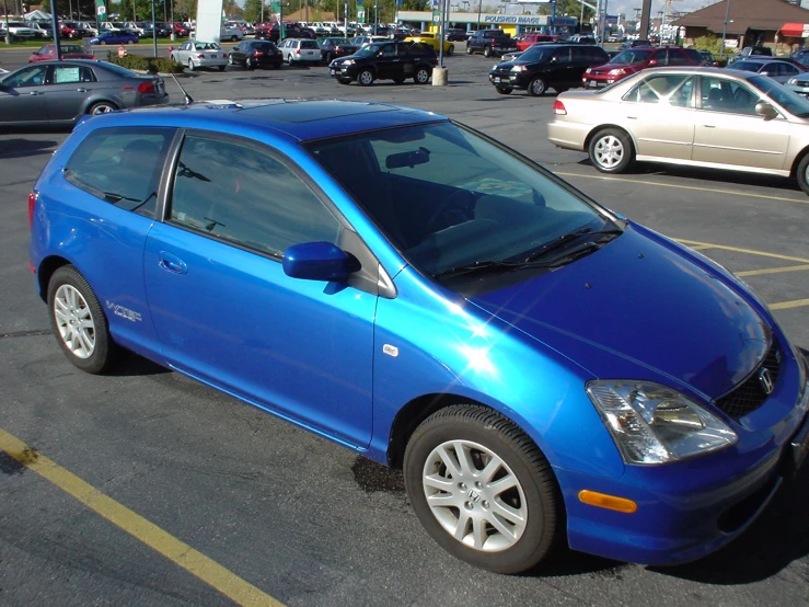 a blue sedan parked in a parking lot