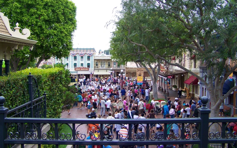 a crowd of people walking down a street next to houses