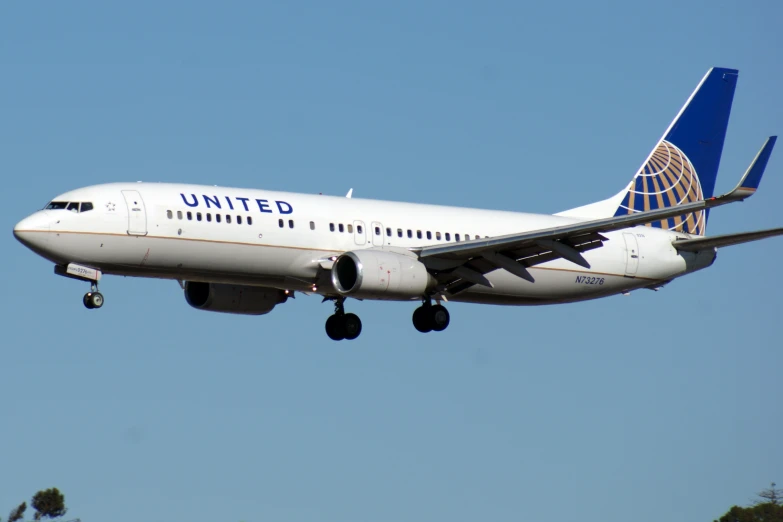 a white airplane with blue writing in the air