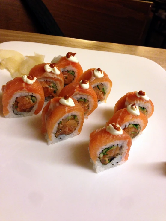 four sushi rolls sit on a plate with garnishes