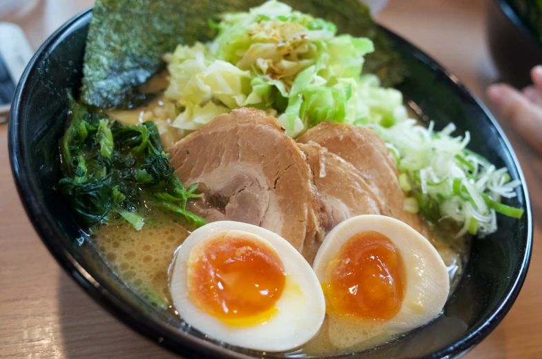 an egg sitting on top of some sliced meat next to a pile of lettuce