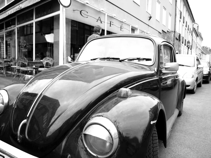 an old vintage beetle parked outside a shop