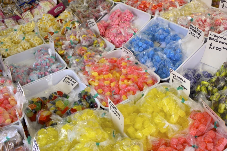 the various candies are in plastic bins