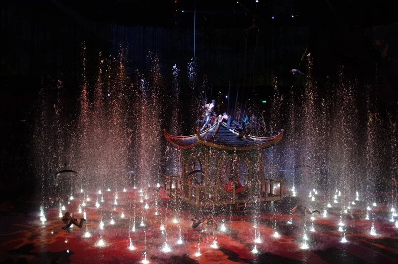 the fountain with a water feature in the center surrounded by bright lights