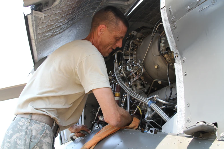 a man looking in the back of an airplane engine