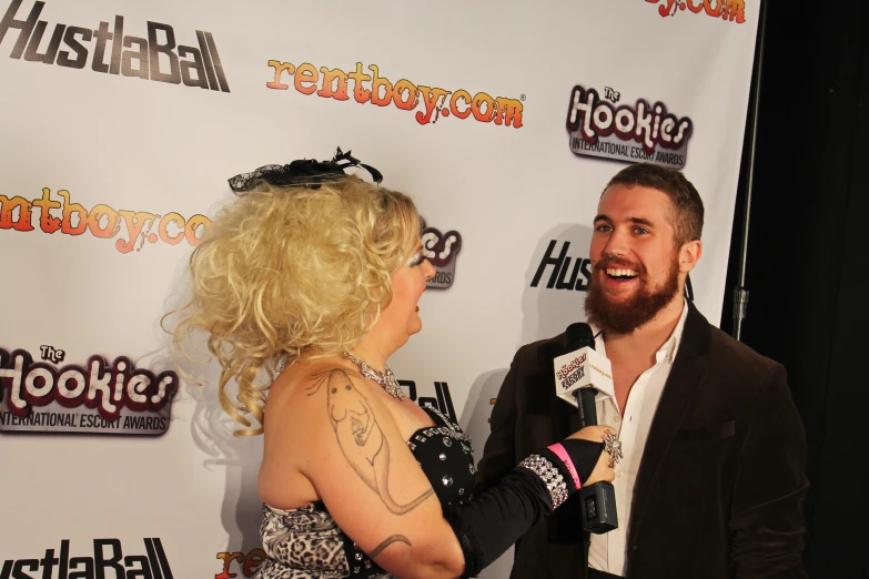 a man talks with a woman on the red carpet