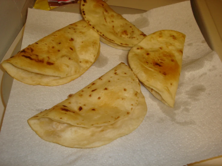 four pieces of cooked flat bread in a box